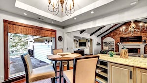 Una cocina amplia con una isla grande, sillas de madera y una pared de ladrillo.