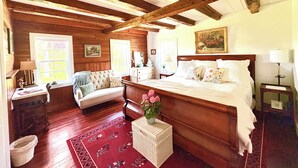 A bedroom with a wooden ceiling, a large bed, a dresser, a chair, and a window. - Located in Ephraim, in the heart of Door County (Sister Bay)