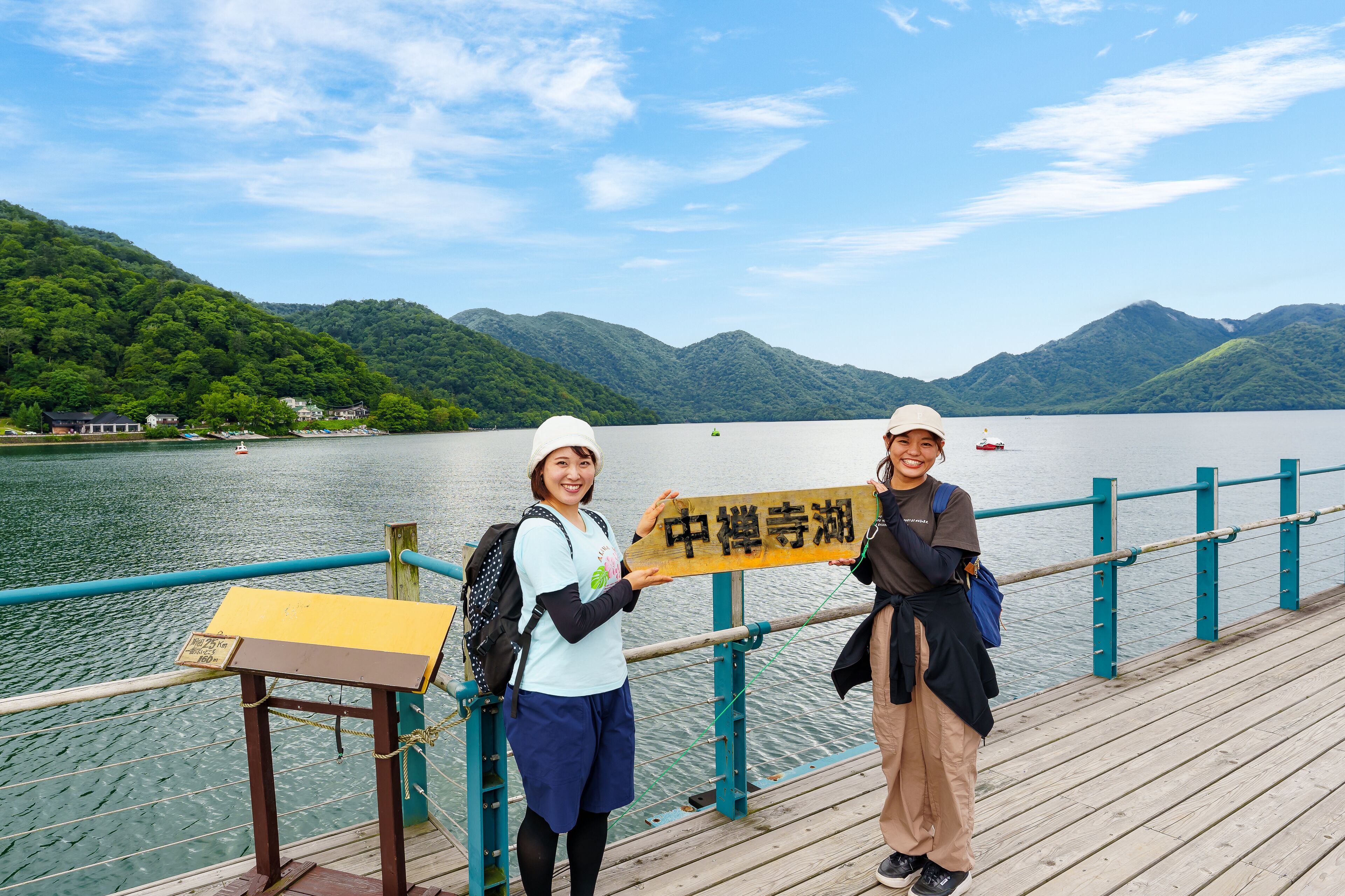 Zwei Personen auf einem hölzernen Steg, mit einem Schild, auf dem '中華寺湖' steht.