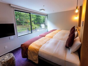 A modern bedroom with a large bed, a TV on the wall, and a window overlooking greenery. - KAMENOI HOTEL NIKKO YUNISHIGAWA ALL-INCLUSIVE RESORT (Nikko)