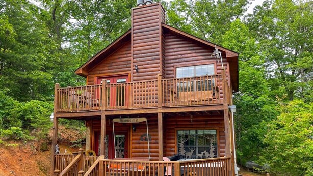 A two-story log cabin with a balcony, a covered porch, and a sign reading 'Summit Up 11'. - Romantic Private Cabin | Hot Tub | Mtn Views, Pets (Sevierville)