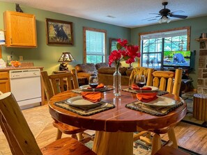 A dining area with a round wooden table set for four, surrounded by wooden chairs. - Romantic Private Cabin | Hot Tub | Mtn Views, Pets (Sevierville)
