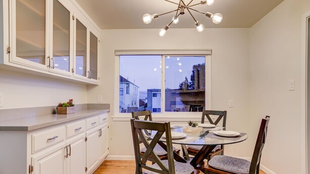A kitchen with white cabinets, a round glass table, and dark wooden chairs. - RUSTIC/MODERN DESIGN, OASIS CITY GETAWAY/NEAR SFO (South San Francisco)