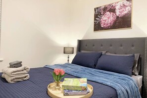 2 habitaciones, escritorio y tabla de planchar con plancha