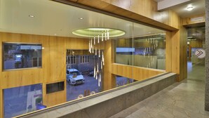 Um interior moderno com painéis de madeira, parede de vidro e luminária pendente.