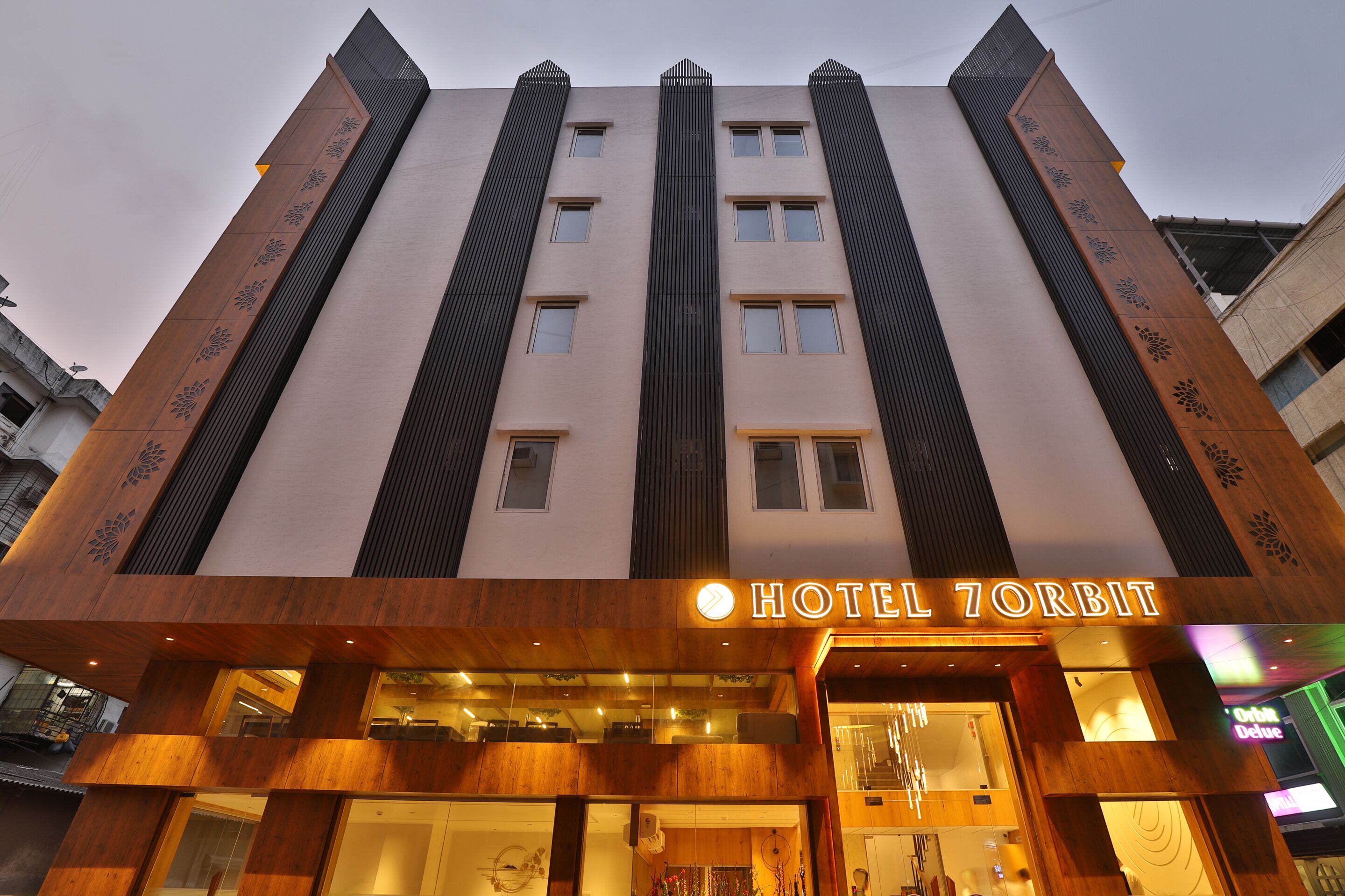 A hotel with a modern facade, featuring vertical wooden panels and a prominent sign reading "HOTEL ZORBIT".