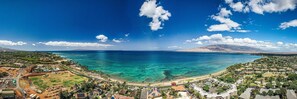 A coastal town with a clear view of the ocean, a beach, and residential areas.