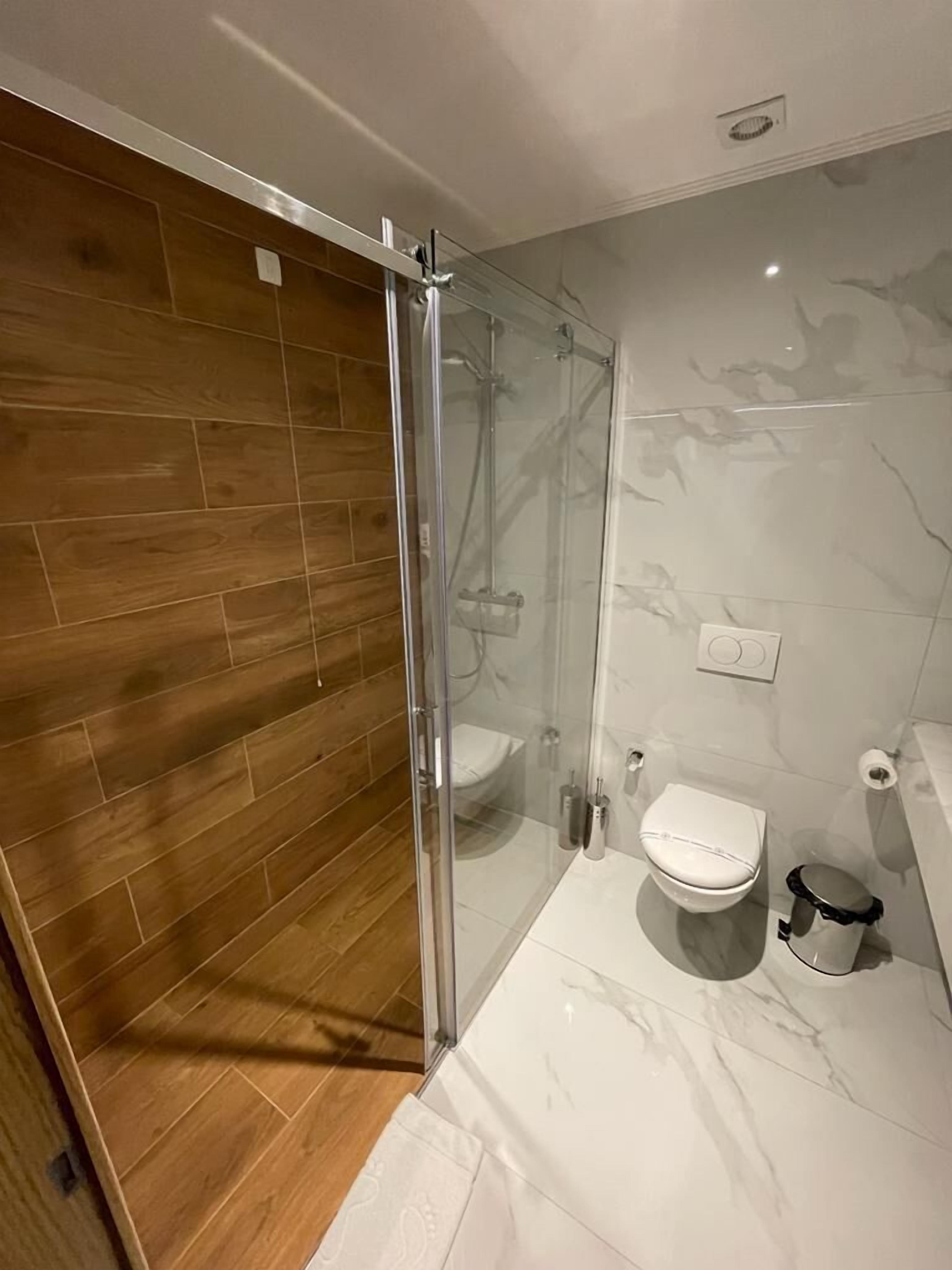 Um banheiro moderno com box de vidro, vaso sanitário e bidê.