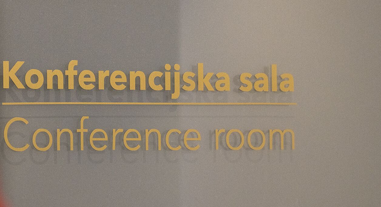 Ein Schild mit der Aufschrift 'Konferencijska sala' und 'Conference room', das auf einen Bereich für Besprechungen oder Konferenzen hinweist.