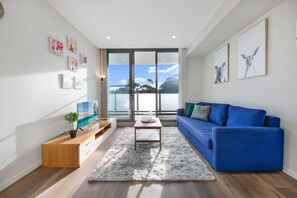 Apartamento, 2 quartos | Sala de estar | TV de tela plana