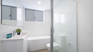 Ein modernes Badezimmer mit Badewanne, Toilette und Duschkabine.