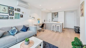 Un appartement moderne comprenant un espace de vie, une kitchenette et un coin repas.