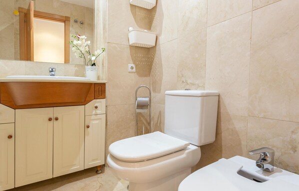 Un baño con inodoro, lavabo y espejo.