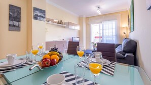 A dining area with a glass table set for breakfast, featuring plates, glasses, and a fruit bowl. - Stunning apartment in Benalmádena with WiFi (Benalmádena)