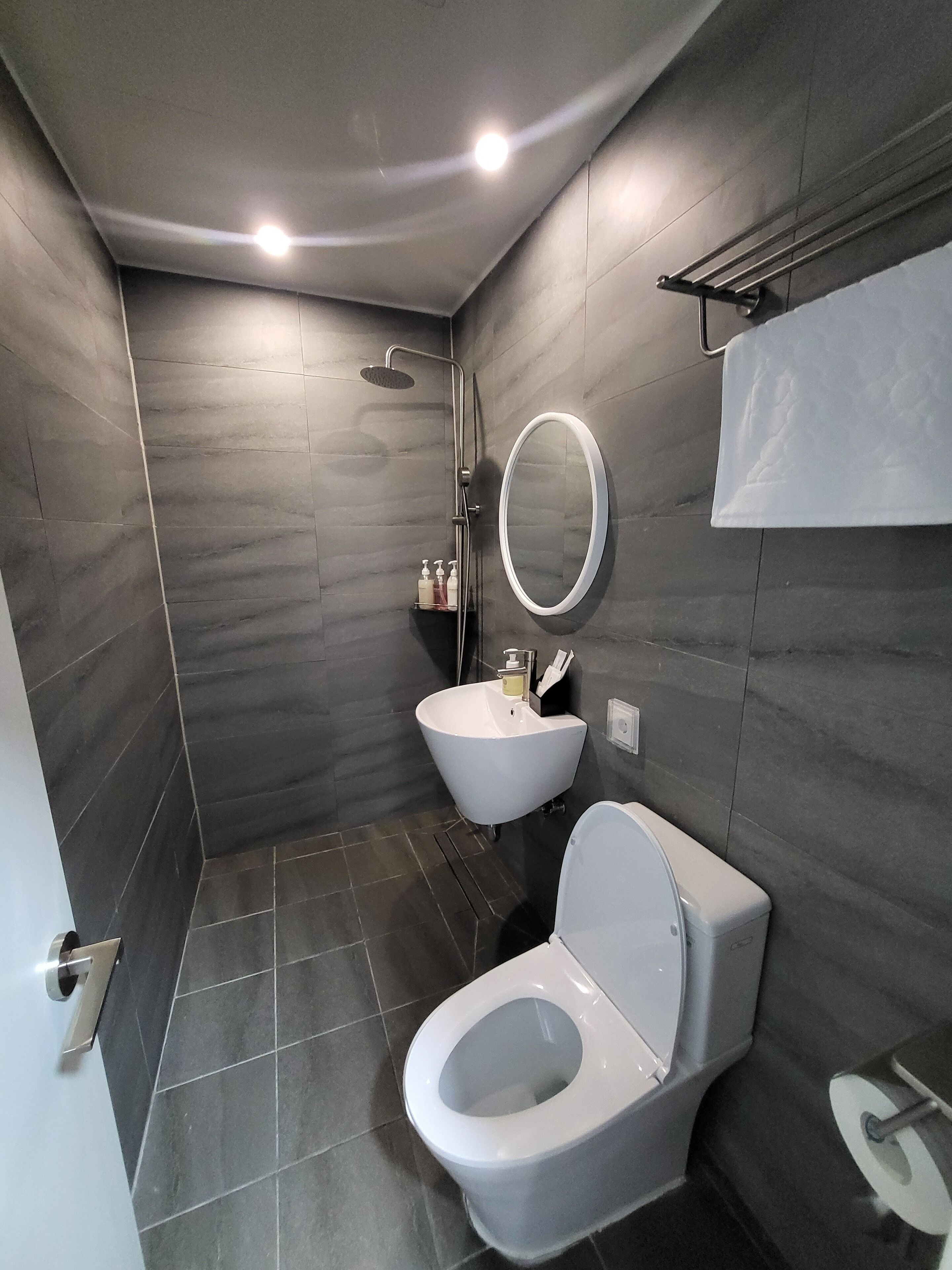Un baño moderno con inodoro, lavamanos y ducha.