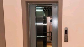 An elevator with a metallic interior and a control panel with red indicators. - Cozy studio with WIFI &Parking in South B (Nairobi)