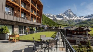 Een modern gebouw met een balkon met uitzicht op een bergachtig landschap.