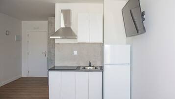 Frigorífico pequeño, microondas, placa de cocina y utensilios de cocina