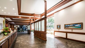 A lobby with a stone floor, wooden paneling, and framed artwork on the walls.