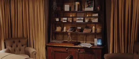 A room with a wooden cabinet, a chair, and a sofa.