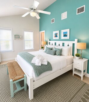 A bedroom with a bed, a bench, a ceiling fan, and a nightstand with a lamp. - Coral Lagoon Updated Single Family Home with 40' Boat Slip directly behind home (Marathon)