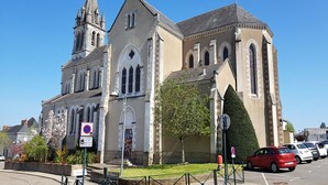 Una iglesia con un campanario alto y ventanas de arco.