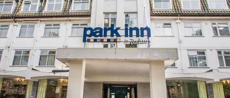 Un hotel con un llamativo letrero 'Park Inn' sobre la entrada.
