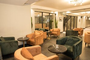 A modern lounge area with seating arrangements, a glass partition, and a staircase in the background. - Park Inn by Radisson Bournemouth (Bournemouth)