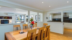 A modern kitchen with white cabinets, a black countertop, and a built-in stove. - Peaceful Waterfront by Book Jervis Bay - wheelchair accessible - Stunning Location for Family Holiday (Sanctuary Point)