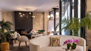 Ein modernes Wohnzimmer mit einem beige gefärbten Sofa, einem Glastisch und Topfpflanzen.
