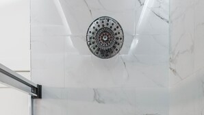A bathroom with a marble floor, a shower with a circular head, and three handheld showerheads. - ❤️ Modern 2BR Apt Right next to Wrigley Field & Transit  (Chicago)