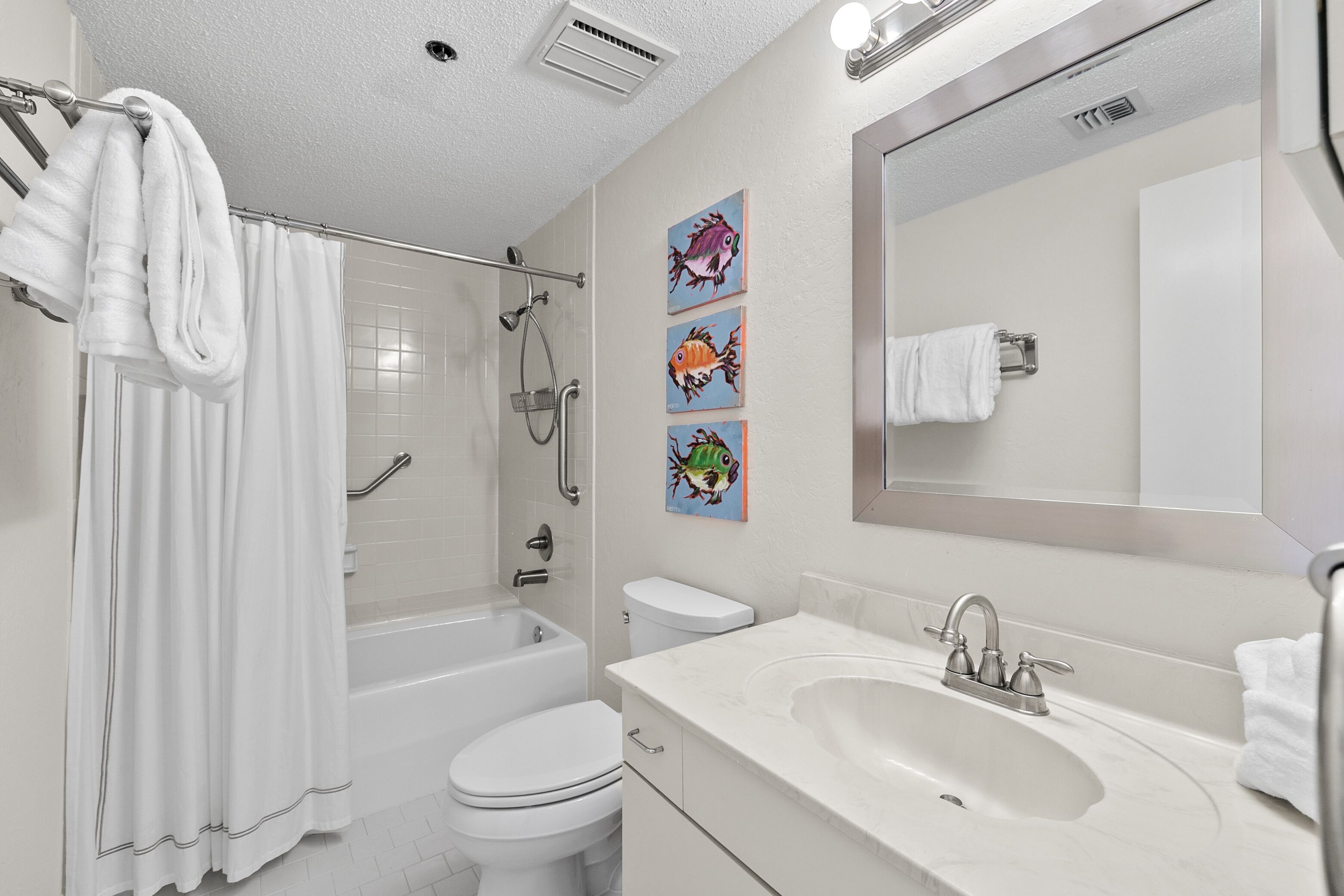 A modern bathroom with a bathtub, toilet, and sink.