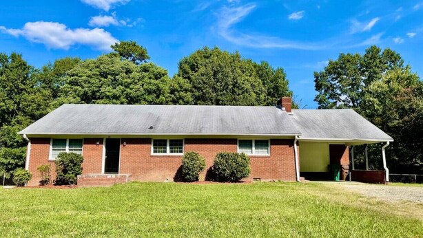 A single-story brick house with a covered porch, a front door, and a small front yard. - Modern High Point Getaway | 3BR, HPU & RV Space (High Point)