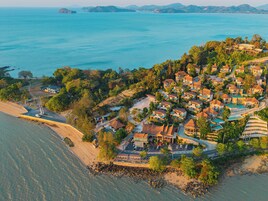 Una zona residencial costera con casas, una playa y una vista despejada del mar.