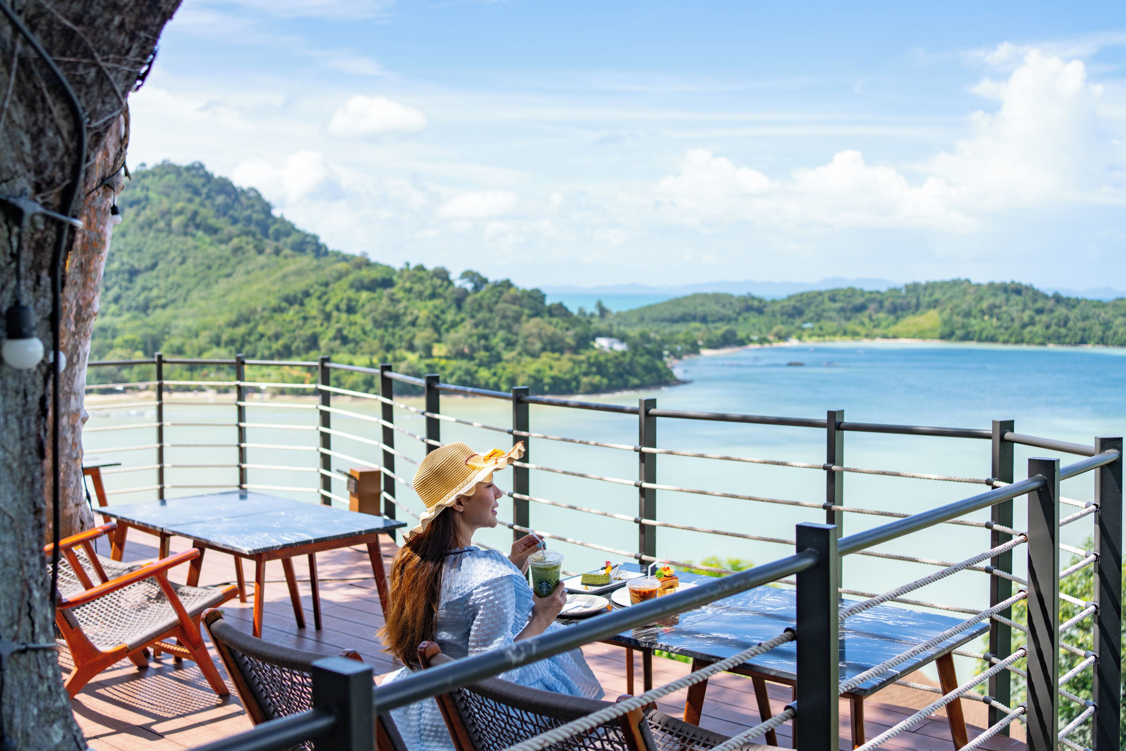 Una terraza con mesas y sillas que da a un paisaje costero.