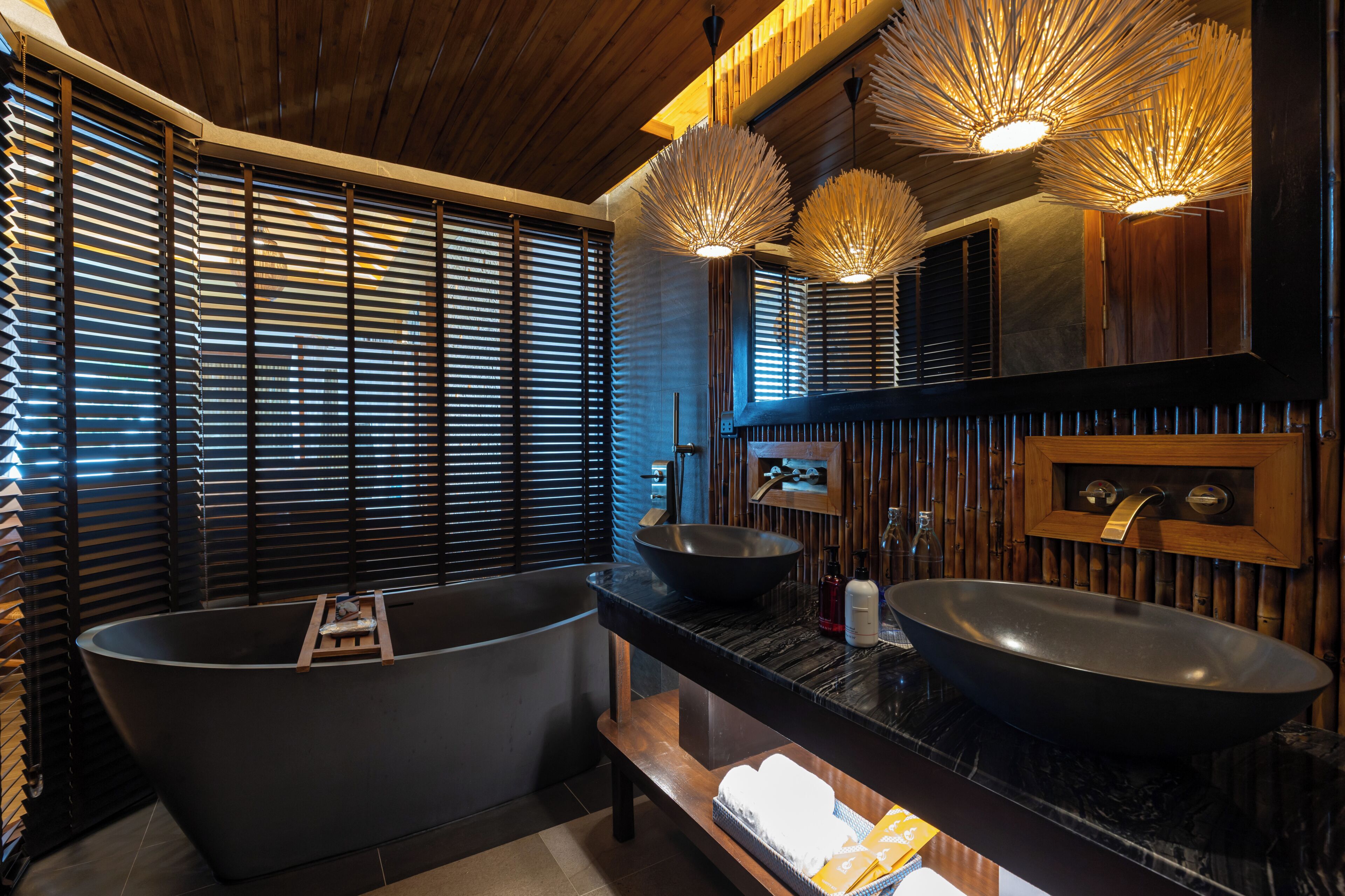 A modern bathroom with a freestanding bathtub, a double sink vanity, and a large mirror.