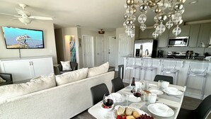 Een moderne keuken met een eethoek, een aan de muur bevestigde televisie en een kroonluchter.