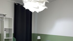 Un dormitorio con cama, mesita de noche, lámpara, un cactus y un armario.