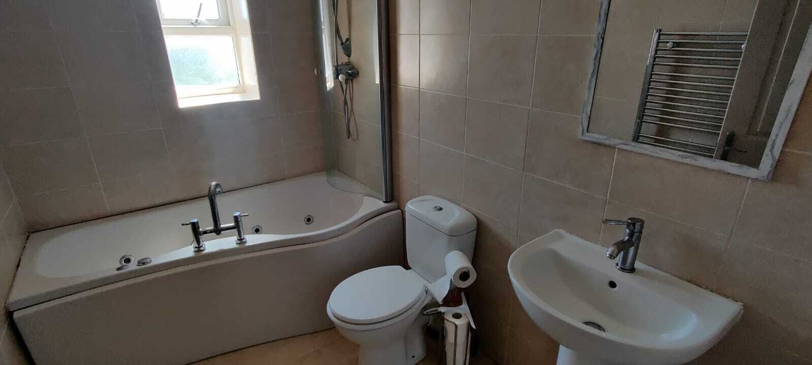 Ein Badezimmer mit Badewanne, Toilette und Waschbecken.