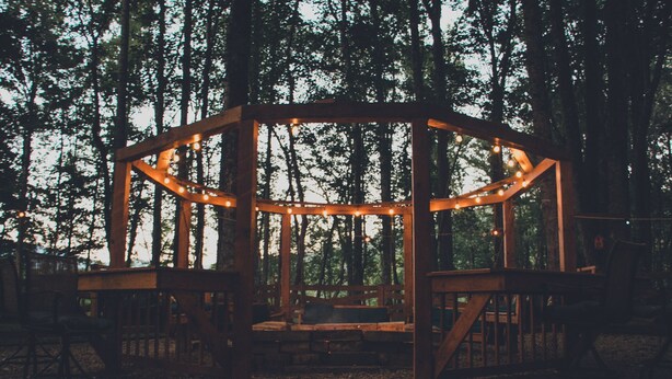 A wooden gazebo with string lights, surrounded by trees. - Private - Secluded Cabin, close to Windrock (Oliver Springs)