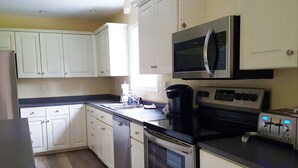 A kitchen with white cabinets, a microwave, a coffee maker, an oven, and a toaster. - Bar Harbor Serenity close to Hadley Point Beach (Bar Harbor)