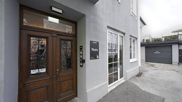 Una entrada de edificio con una puerta doble de madera, una puerta de cristal y una puerta de garaje.
