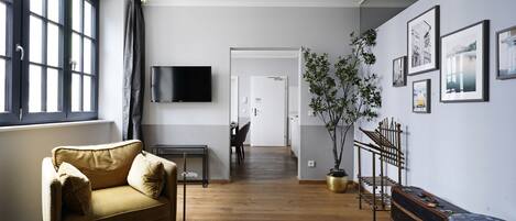 A modern living room with a sofa, a TV, and a plant.