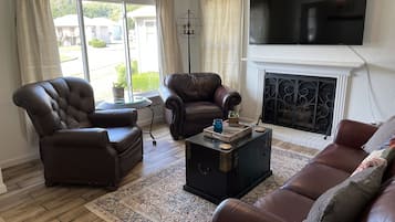 Smart TV, chimenea, libros, biblioteca de música