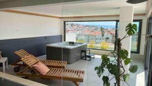Un balcon moderne avec un fauteuil de relaxation, une petite table et une plante en pot.