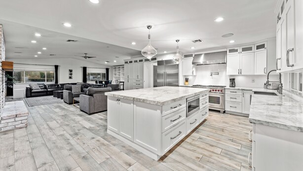 A spacious kitchen with white cabinetry, a large island, and modern appliances. - 7BR Luxury Retreat - Cedar Sauna, Gym, Heated Pool, Spa, Basketball & Foosball (Scottsdale)