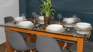 A dining table set with plates, glasses, and cutlery, surrounded by chairs. - Sydney Wharf House (Bath)