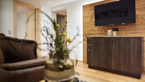 Una sala de estar moderna con un mueble de madera, un televisor de pantalla plana montado en una pared de madera y un sofá marrón.