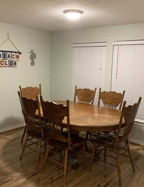 A dining room with a round wooden table and six chairs. - First row Gulf views! (Bolivar Peninsula)