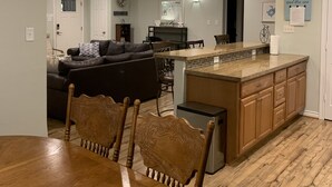 Een ruime keuken met een centraal eiland, een houten eettafel en stoelen.